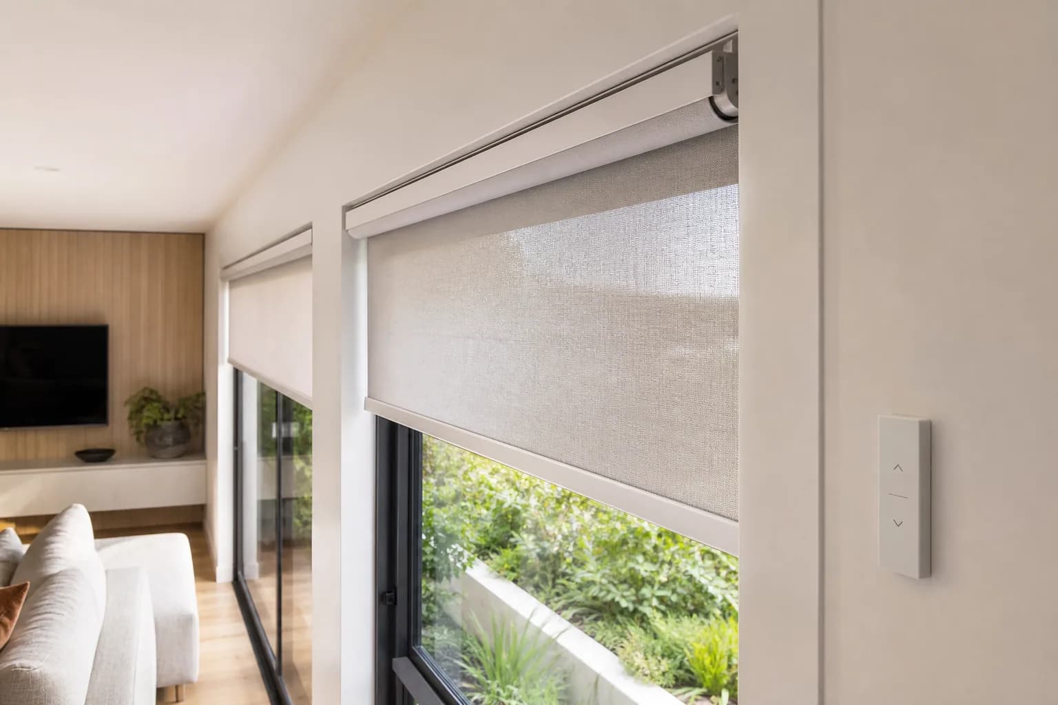 Close-up of a professionally installed motorised roller blind with a wall-mounted control
